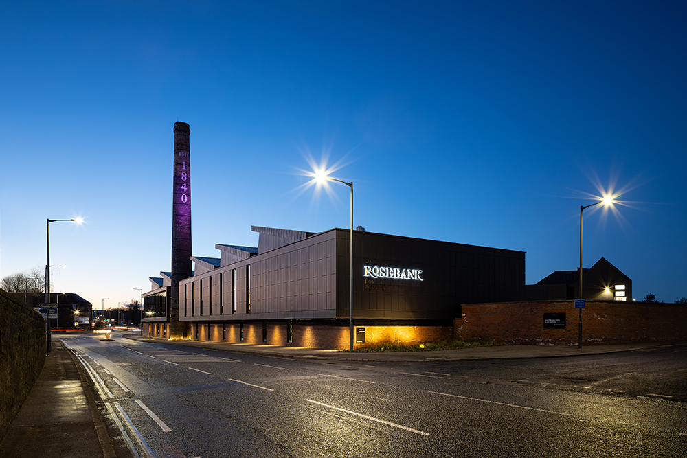 Rosebank Distillery viewed at night with historic tower in background