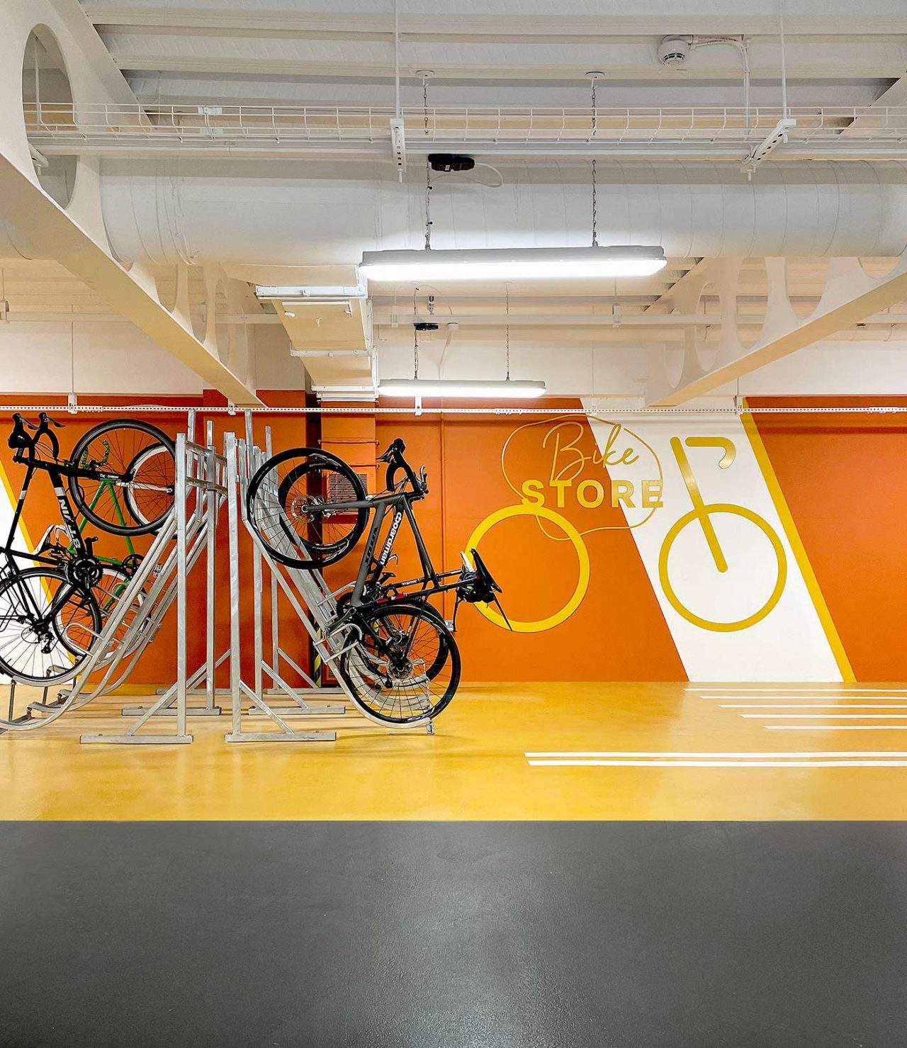 Cycle graphic on orange back wall and bikes stored in foreground